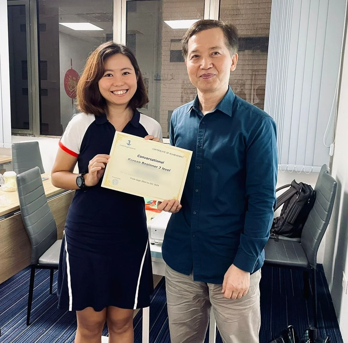 A student receiving her Conversational Korean certificate