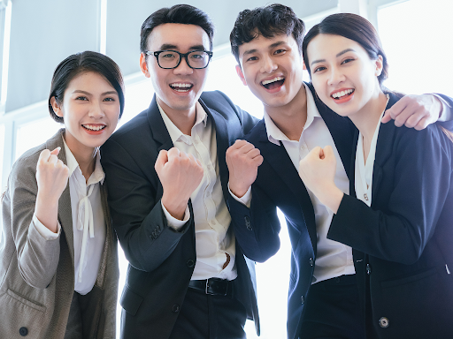 Professionals celebrating teamwork reflecting Korean workplace communication culture