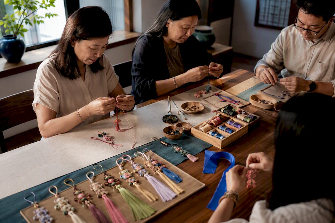 Adults making norigae at cultural workshop