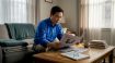 Man reading Korean newspaper at home table