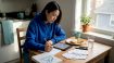 Woman practicing Korean vocabulary at kitchen table