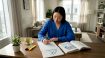 Woman practices Korean writing at home desk