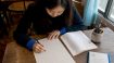 Woman practicing Korean Hangul writing at desk