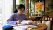Woman studying Korean language exam materials at home