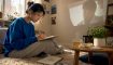 Woman watching Korean drama and taking notes