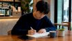 Student practicing Korean counting with textbook