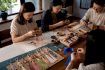 Adults making norigae at cultural workshop